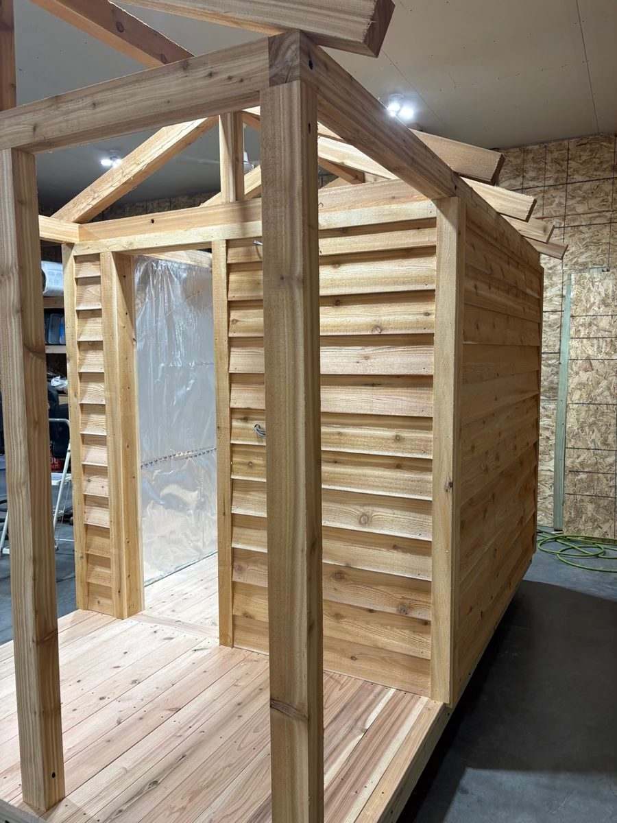 Cedar lap siding, porch posts and a foil vapor barrier on a sauna under construction
