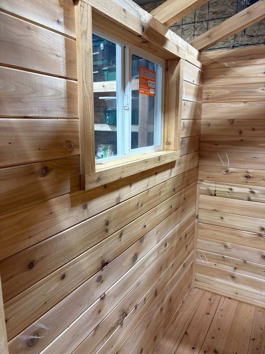 Cedar tongue-and-groove interior walls and a window in a sauna under construction